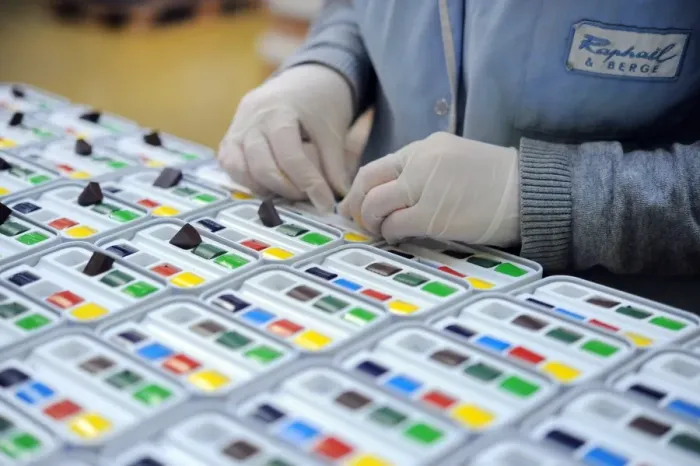 Framed Print : An employee fills pastel boxes in a workshop at the Raphael-Isabey-Sennelier factory