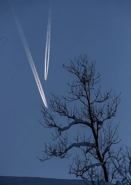 Feature-Austria-Ski. Planes traces cross in the sky over the slalom course