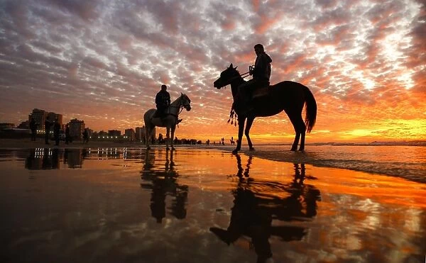 Gaza-Horses-Sunset. Men riding horses on the beach as the sun sets over