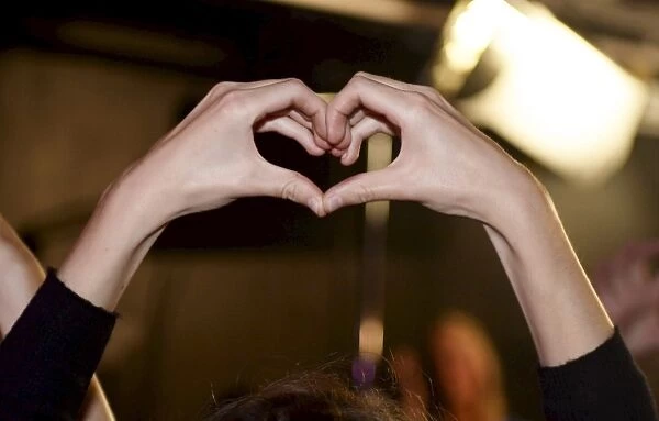 A heart shape is formed by a participant of the Feminist Initiative election night