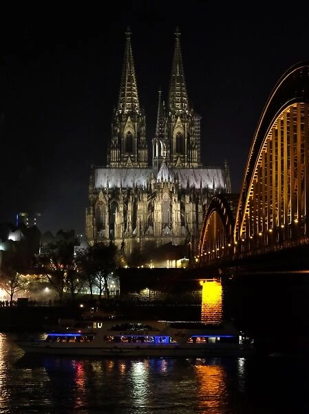 The Hohenzollern bridge is seen in front of the Cologne cathedral on December 31