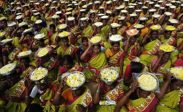 India-Flowers-Women. Indian women carry plates of flower for an offering