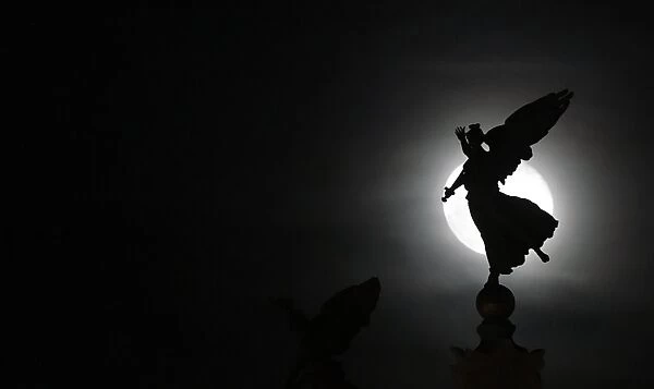 Italy-Features. The moon is seen behind Vittoriano statue in central Rome on January 14