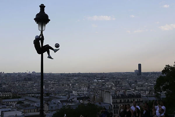 Iya Traore, a former professional football player, holds on to a lamppost as he performs