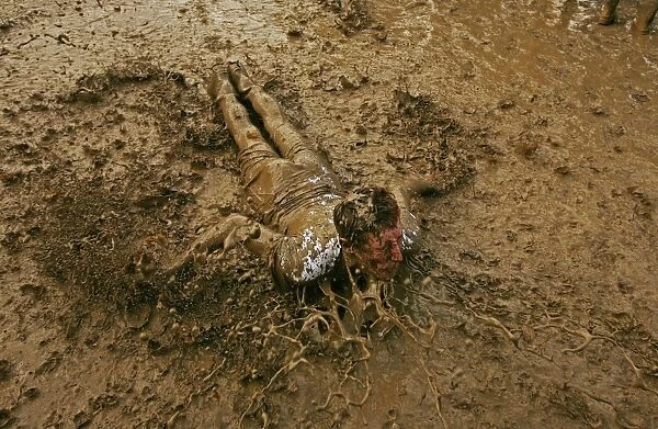 A music fan slides in the mud, at the Glastonbury music festival, Pilton, Somerset 22 June 2007