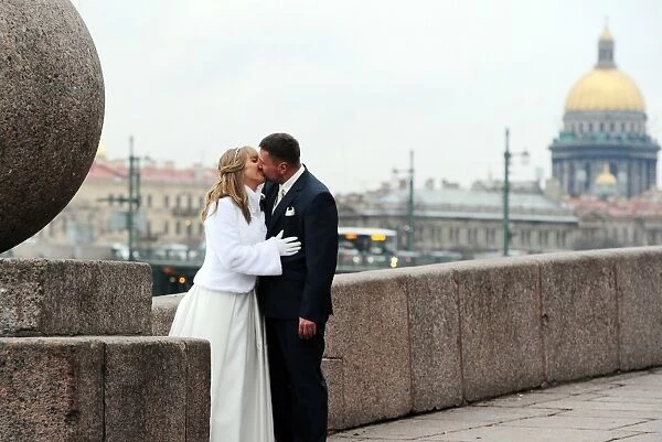A newly married couple kisses in St. Petersburg on February 14, 2014