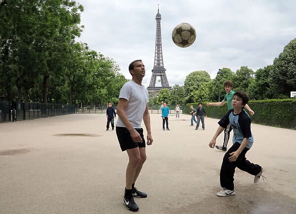 People play football on May 29, 2014 in front of the Eiffel tower, in Paris