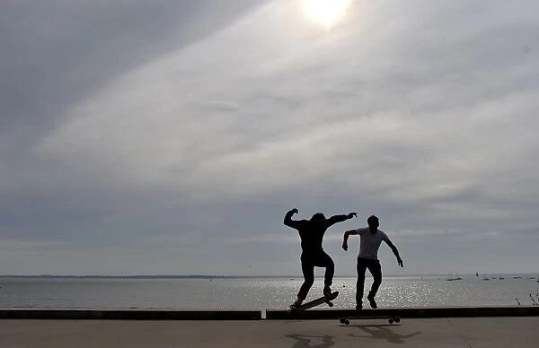 People ride a skateboard along the beach on October 7, 2016 in Saint-Nazaire, western France