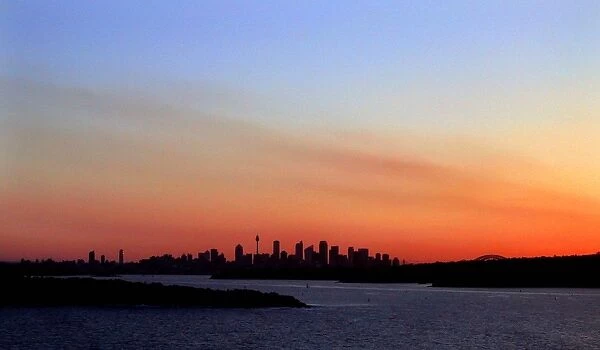 Sydney-Sunset. The sun sets behind Sydney harbour silhoueting the downtown skyline