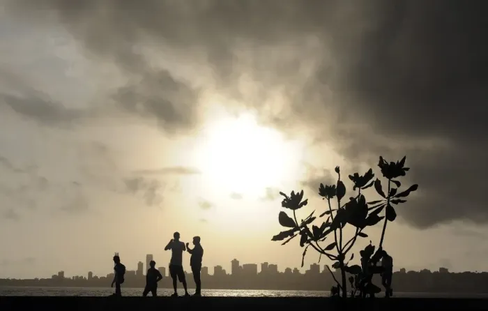 Framed Print : TOPSHOTS Indians stroll near the seafront as dark clouds gather over city skyline