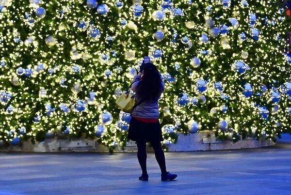 Us-Christmas. A woman takes photos of the Christmas tree at CityCenterDC