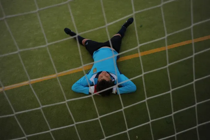 Framed Print : A young player of the Ronda Union Deportiva football club rests on the field during Framed Print : A young player of the Ronda Union Deportiva football club rests on the field during
