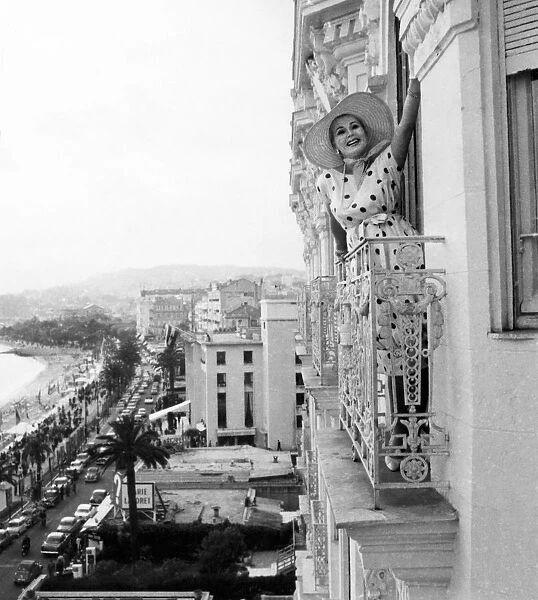 Zsa Zsa Gabor poses from the window of her apartment