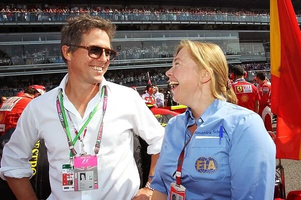 Formula One World Championship: Hugh Grant Actor on the grid with Alexandra Schieren, FIA Press Delegate on the grid