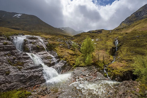Waterfall in the Scottish Highlands with cloudy sky in Scotland, United Kingdom