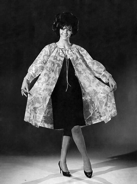 Model Jo-Ann Asher wearing a knee length dress with coat over the top. July 1965