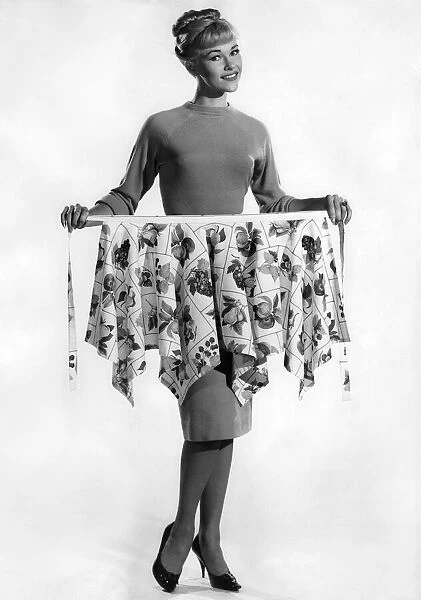 Model Jo Waring holding up a floral skirt. December 1961 P008815