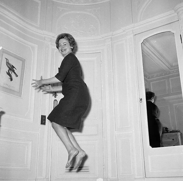 Olivia De Havilland playing a jumping game with her husband. 20th November 1959