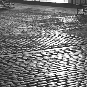 Early morning sunshine on cobbles in Tower Gardens, London