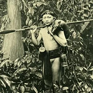 Kayan man with piglet and blowpipe, Borneo, SE Asia