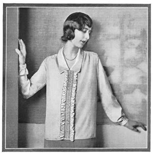 A model wearing a loose blouse with a ruffle. Date: 1920s