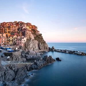 Beautiful sunset light shines on the colourful town of Manarola during a long exposure
