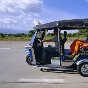 Buddhist monk in a tuk tuk taxi