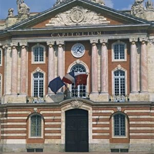 Flags flying below a clock on the Capitole building in Toulouse, Haute Garonne