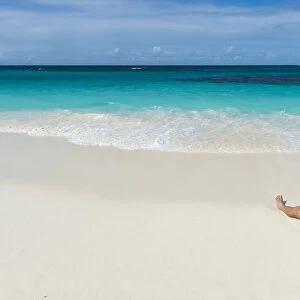 Man relaxing on the world class Shoal Bay East beach, Anguilla, British Oversea territory