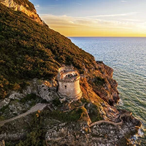 Medieval round tower standing on top of a cliff facing the sea at sunset, aerial shot, Sabaudia, Circeo National Park, Latina province, Latium, Lazio, Italy, Europe