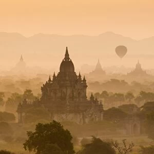 Bagan, Mandalay region, Myanmar (Burma). Pagodas and temples with balloons at sunrise