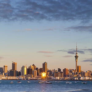 City skyline & Waitemata Harbour illuminated at sunset, Auckland, North Island, New