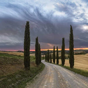 Podere Baccoleno in summer during a stormy sunset, Crete Senesi, Tuscany, Italy