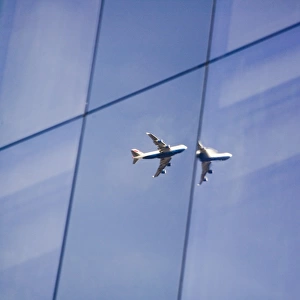 A jet reflected in a Glass fronted building in More London Place London UK