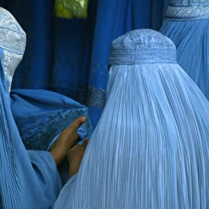 AFGHAN WOMEN PURCHASE BURQAS AT A ROADSIDE SHOP IN KABUL