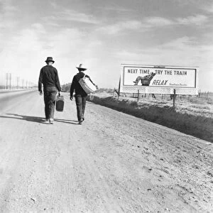 HITCHHIKERS, 1937. Two hitchhikers on their way to Los Angeles, California. Beside them
