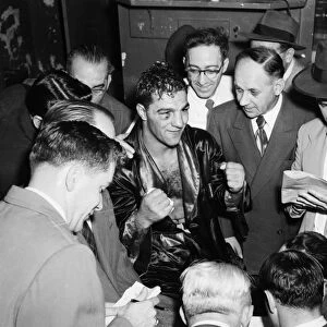 ROCKY MARCIANO (1924-1969). American boxer. Marciano talking with reporters after his victory against Joe Louis at Madison Square Garden in New York City, 26 October 1951