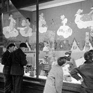 WINDOW SHOPPING, 1940. Window shoppers looking at toys in the window display of