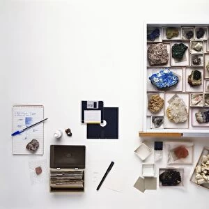 Rock collection with notepad, pen, card index box, correction fluid, index cards, drawer containing boxes of rocks, specimen labels