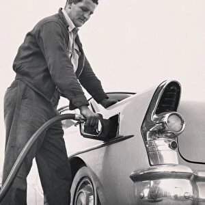 Worker pumping gas into a Buick