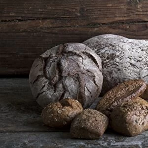 Bread loaves and rolls on a rustic wooden surface