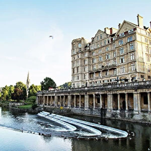 the Empire and River Avon weir in late afternoon sunlight, Bath, UK