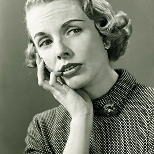 Thoughtful woman posing in studio, (B&W), portrait