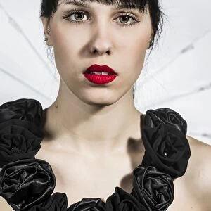 Young woman in black dress with fabric roses, portrait