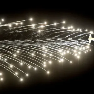 Print of a C-130 Hercules releasing flares at an airshow