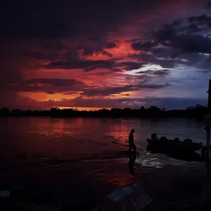Print of a man wading through a lake at sunset in Pantanal, Brazil