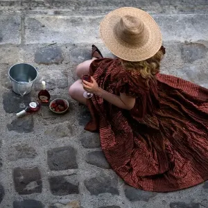 A woman sits on the Seine riverbank with a glass of wine in Paris A woman sits on the Seine riverbank with a glass of wine in Paris