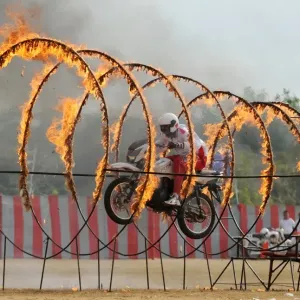 Print of a motorbike display team member riding through rings of fire Print of a motorbike display team member riding through rings of fire