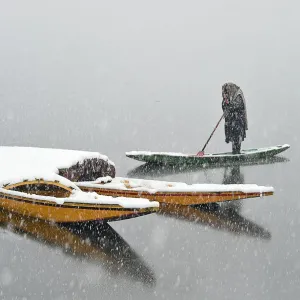 Print of a Kashmiri boatman on Dal Lake during snowfall