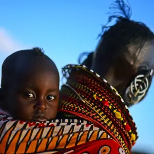 Print of a Turkana woman carrying a baby in Northern Kenya
